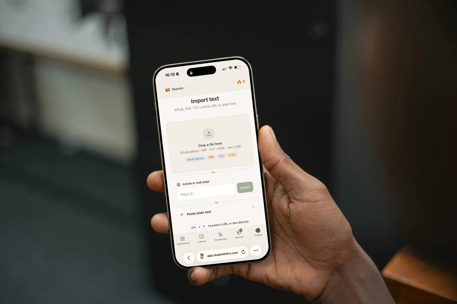 Une main tient un iPhone affichant l'écran d'import de texte de Lira, avec les options EPUB, PDF, TXT et HTML.